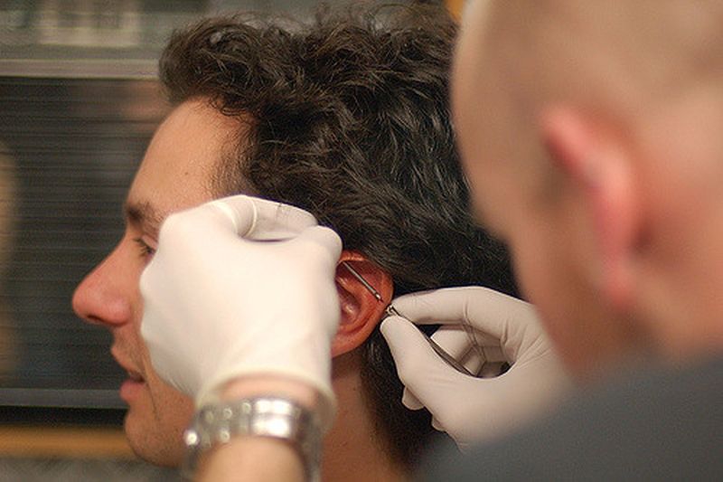 Muž si nechává udělat piercing ucha ve studiu